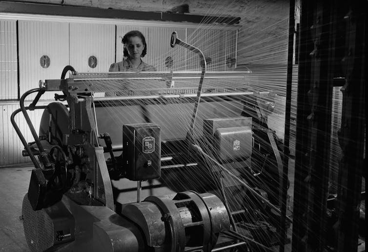 A woman at a warping machine.