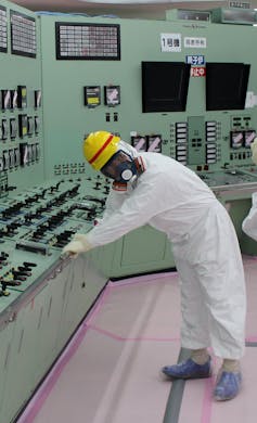 Man in protective radiation suit and respirator.