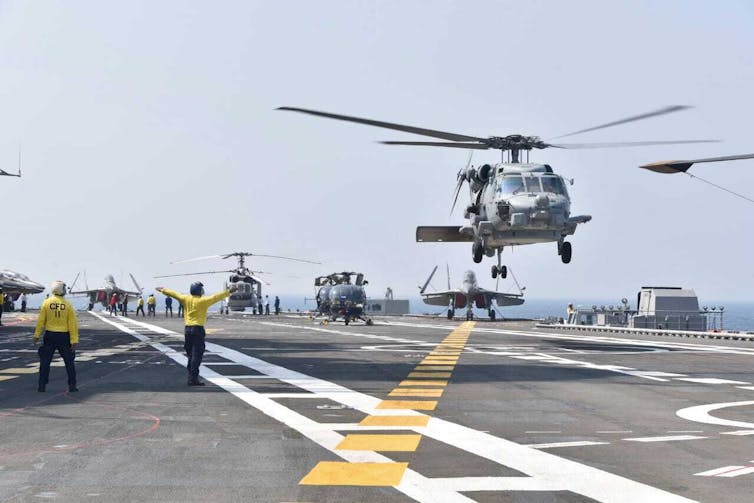 Helicopters landing on an aircraft carrier