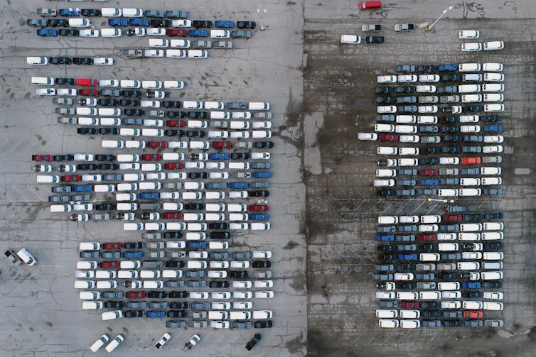 an aerial photo of mid-sized pickup trucks and full-size vans in a parking lot