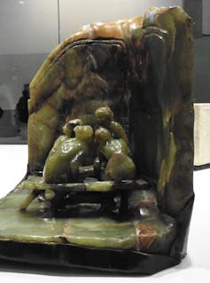 Sculpture showing four women huddled in a corner talking.