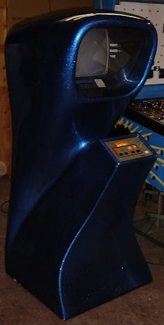 A vertical curvey arcade game console with four buttons on a control surface at the front and a hooded television screen at the top