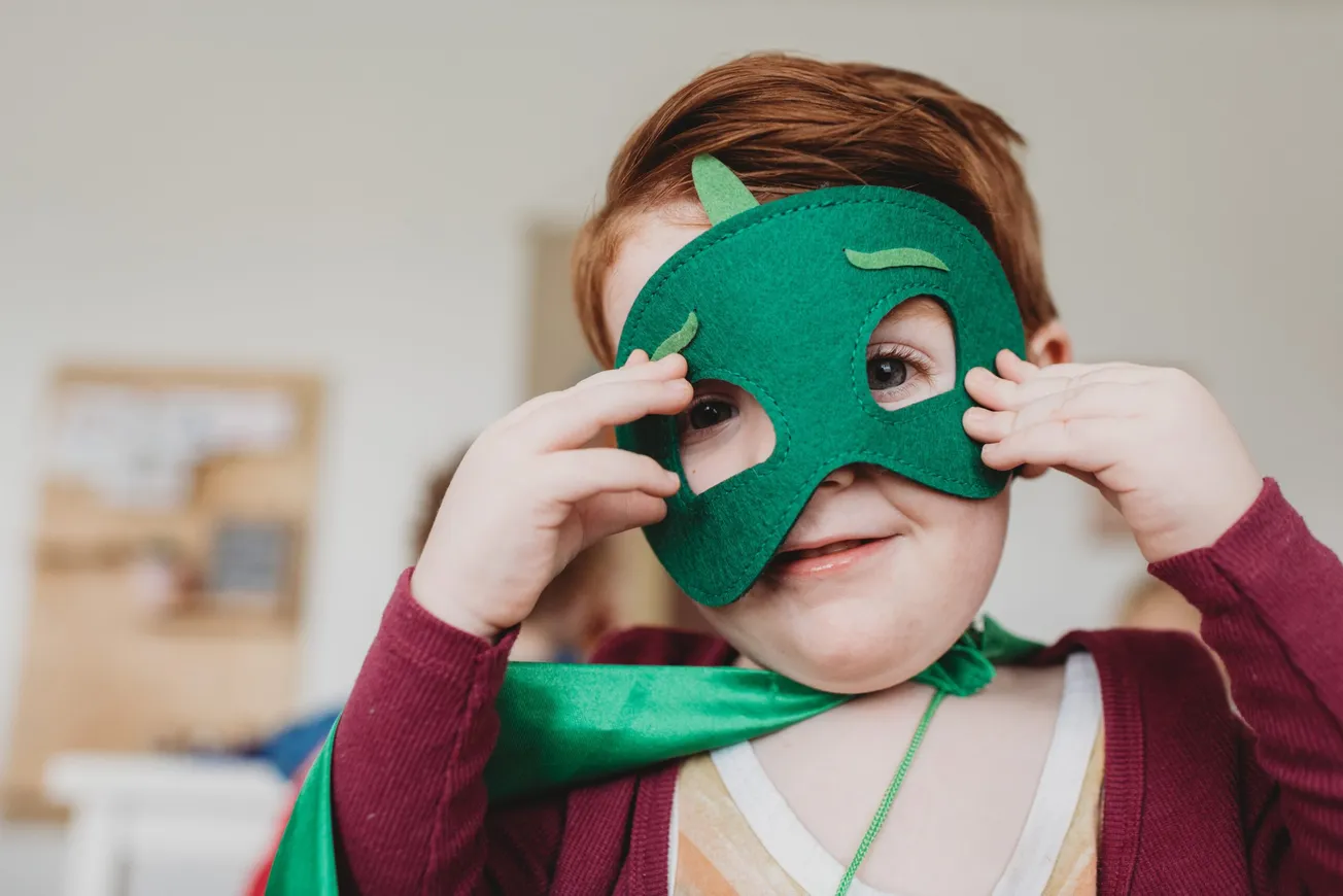 boy holding green mask