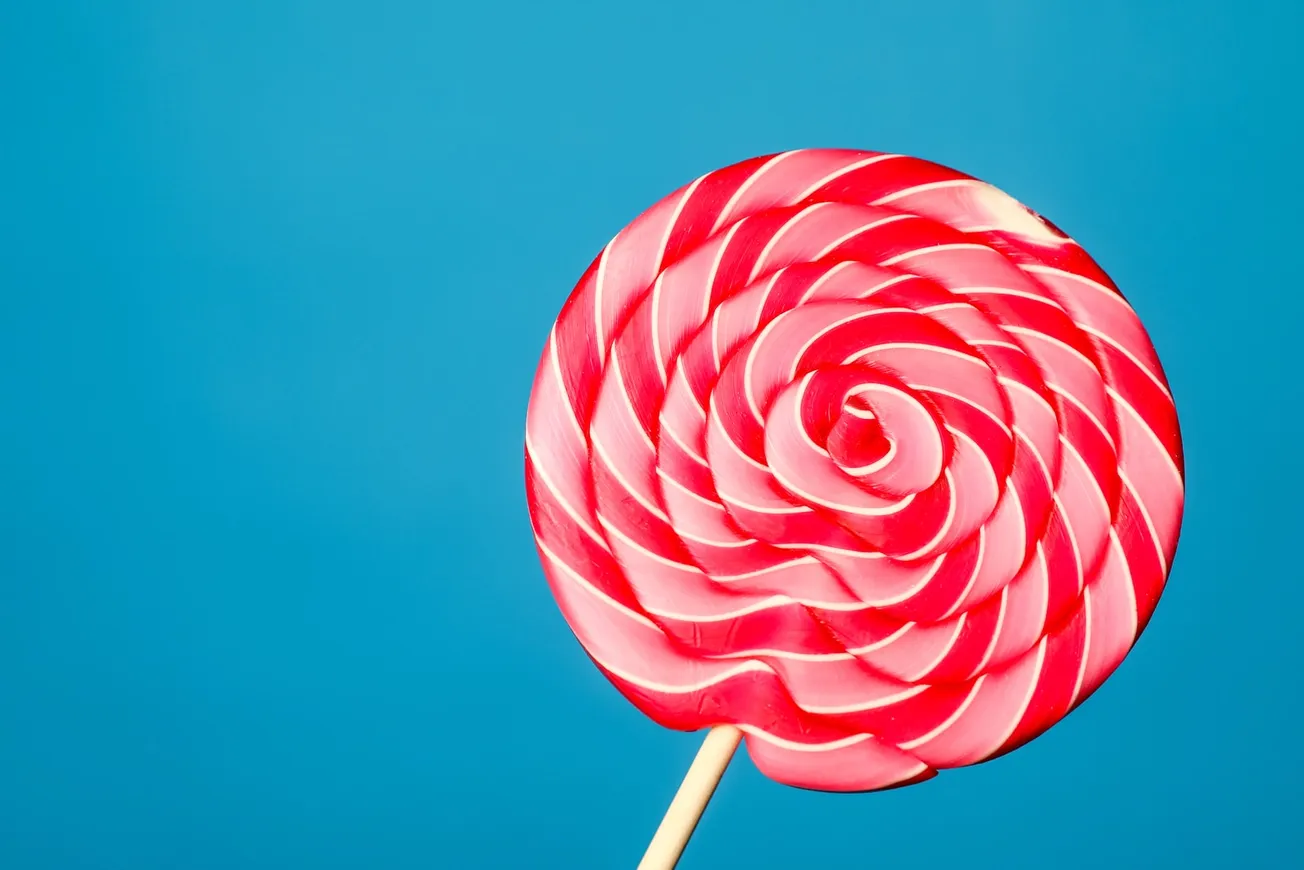 white and red lollipop on blue background