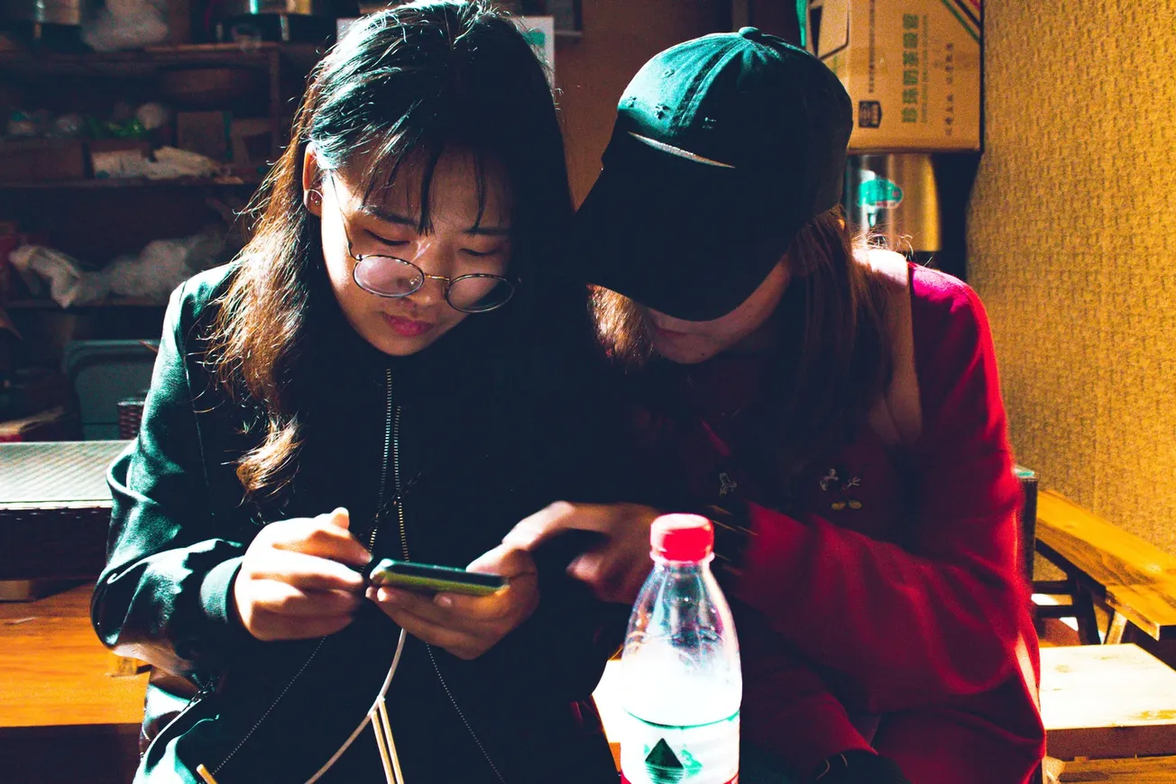 two women looking at a smartphone
