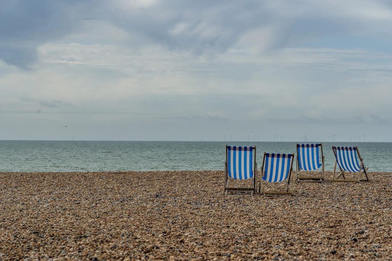 blue and white beach chairs on beach during daytime