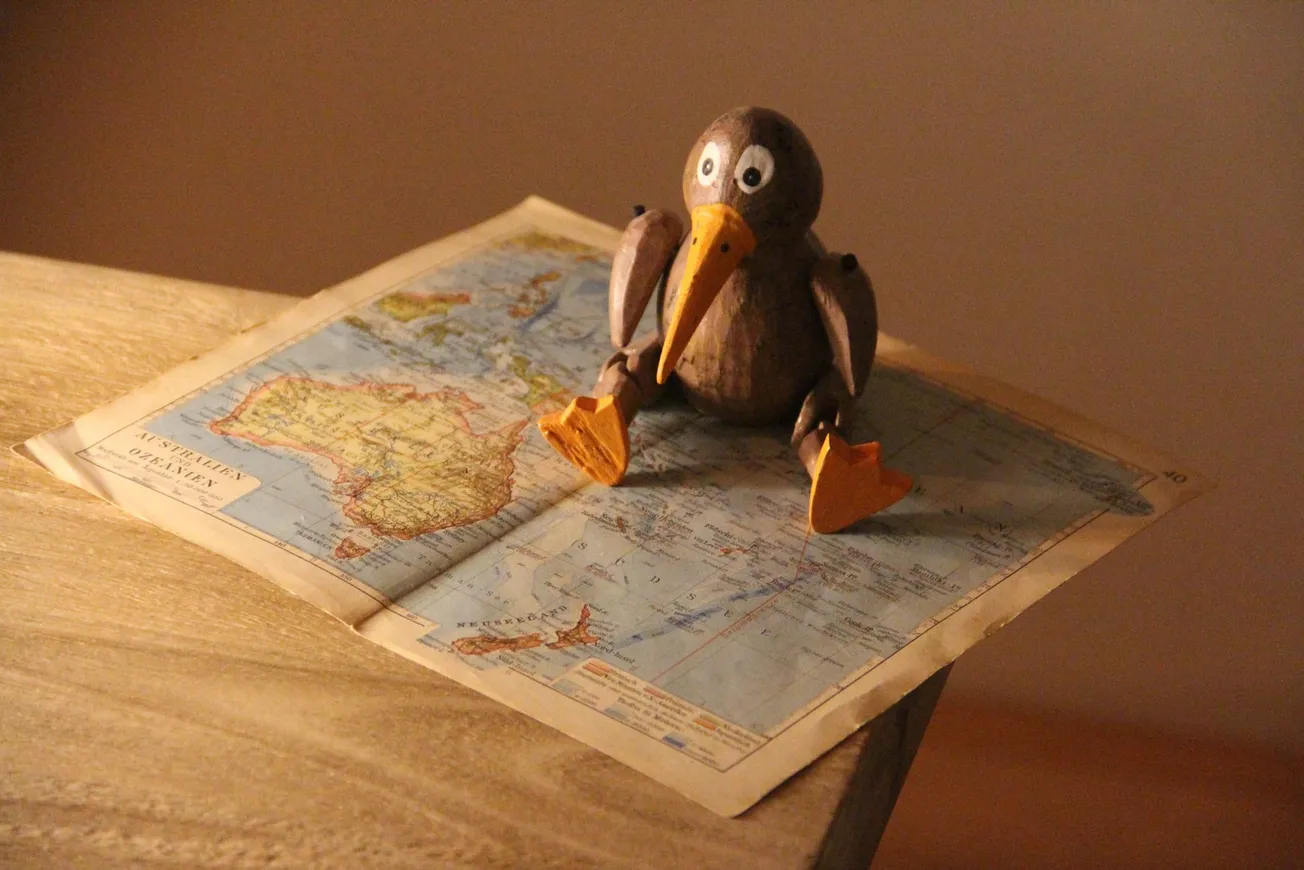 black and yellow penguin figurine on white table