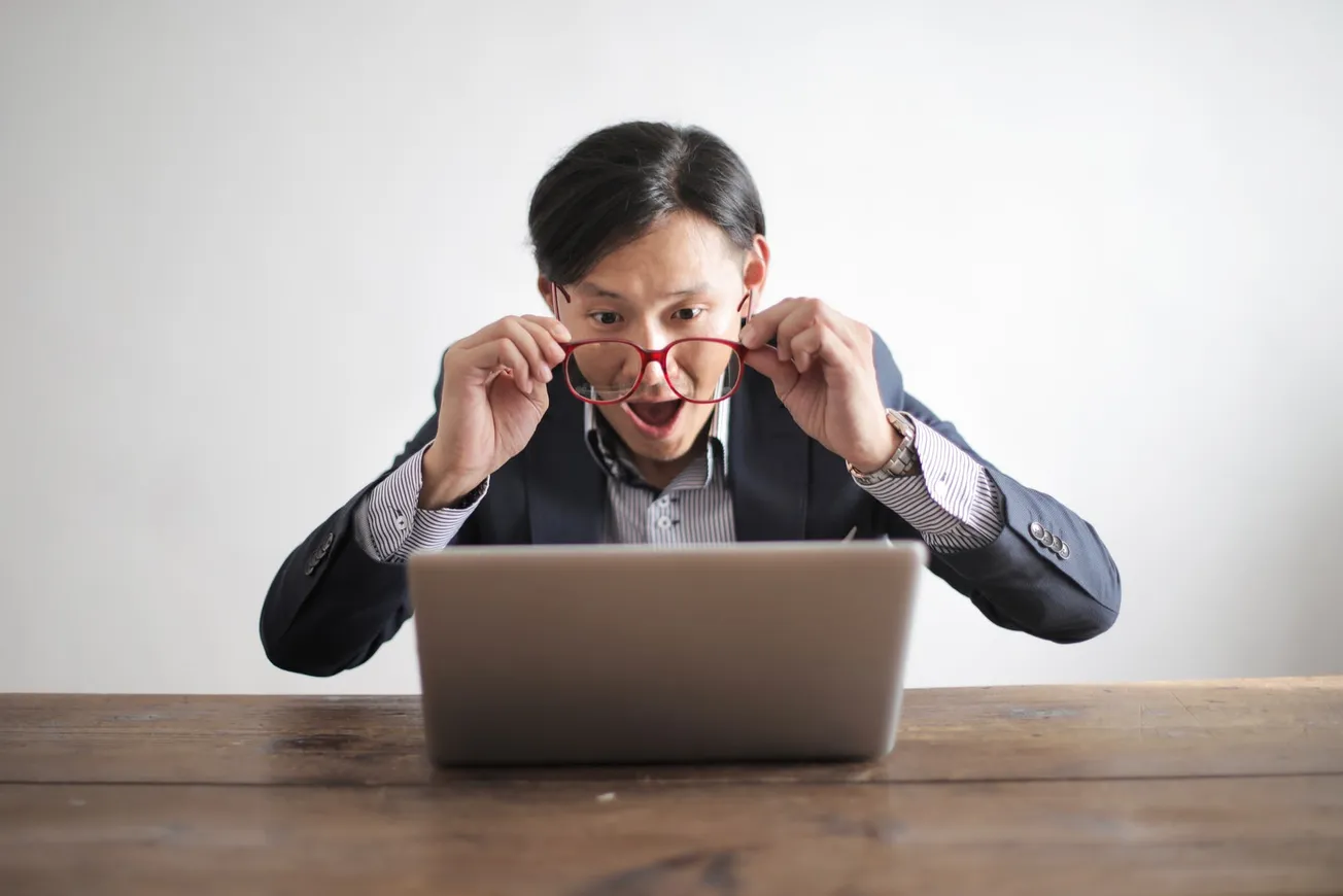 Amazed formal male looking at laptop screen