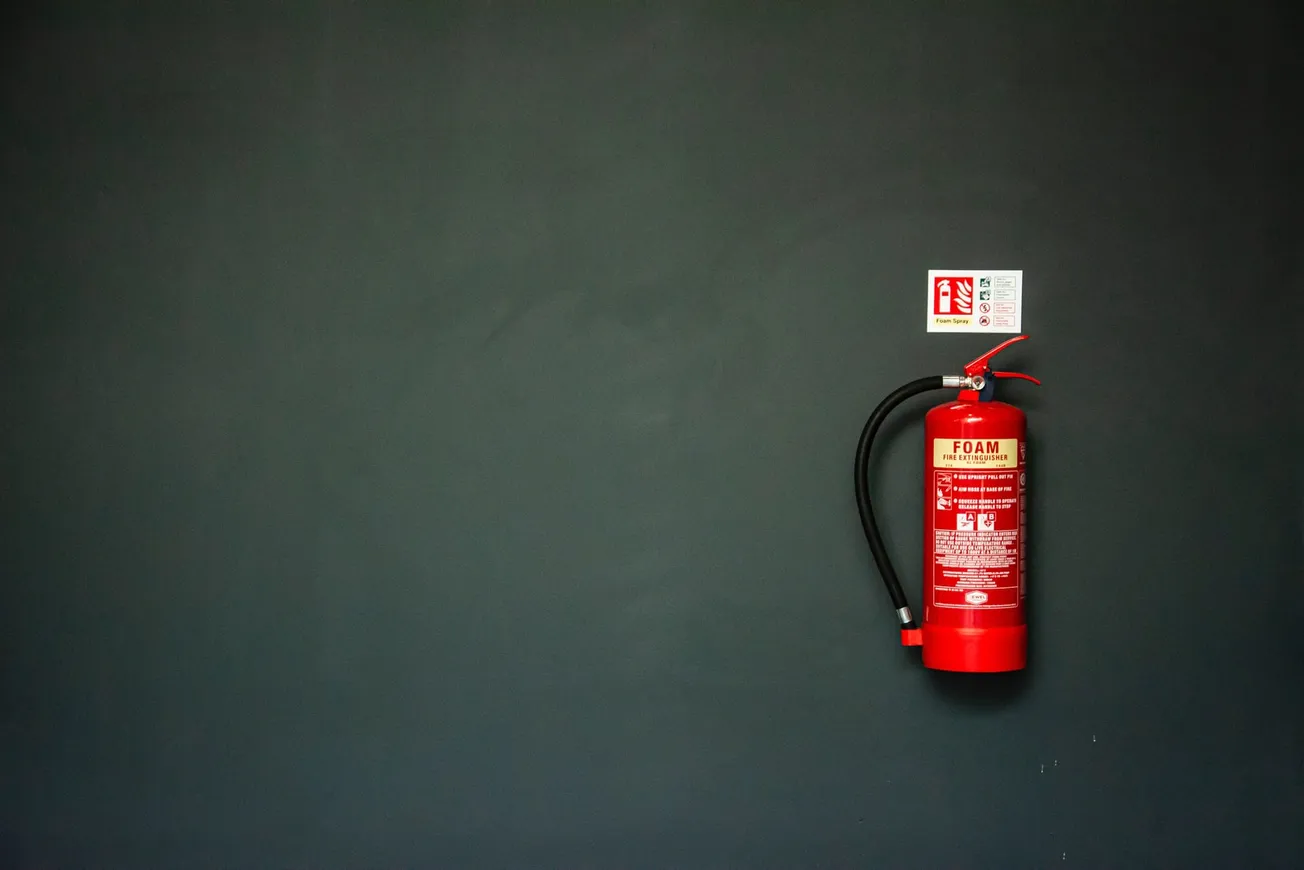 red fire extinguisher on gray wall