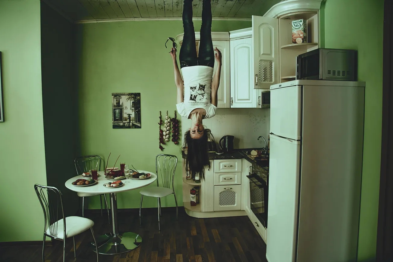 Woman Standing on Ceiling Inside Room