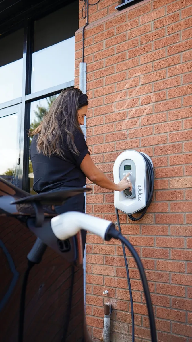 woman in black shirt and white pants sitting on black and white stationary bike