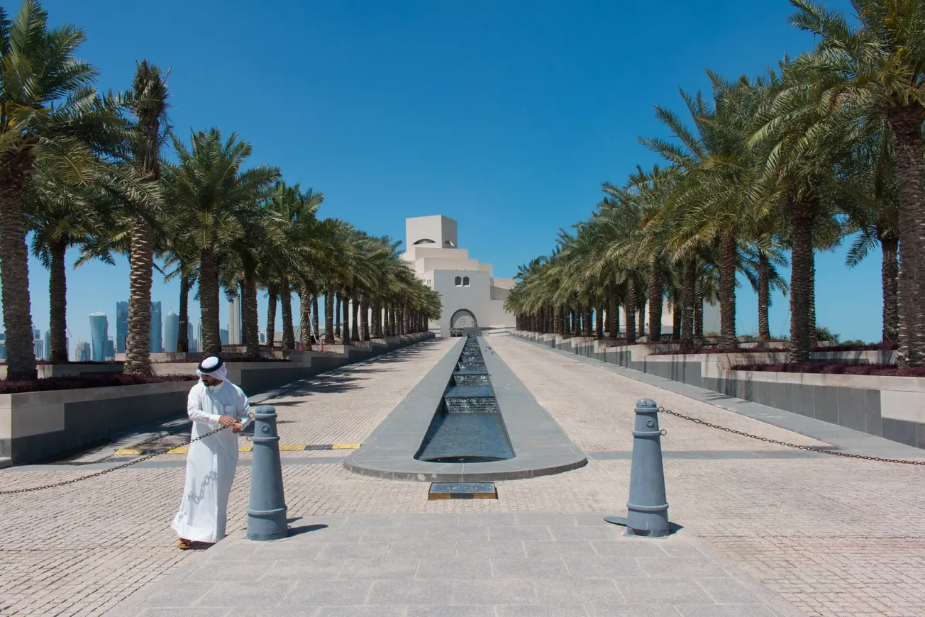 woman in white dress standing on gray concrete pathway during daytime