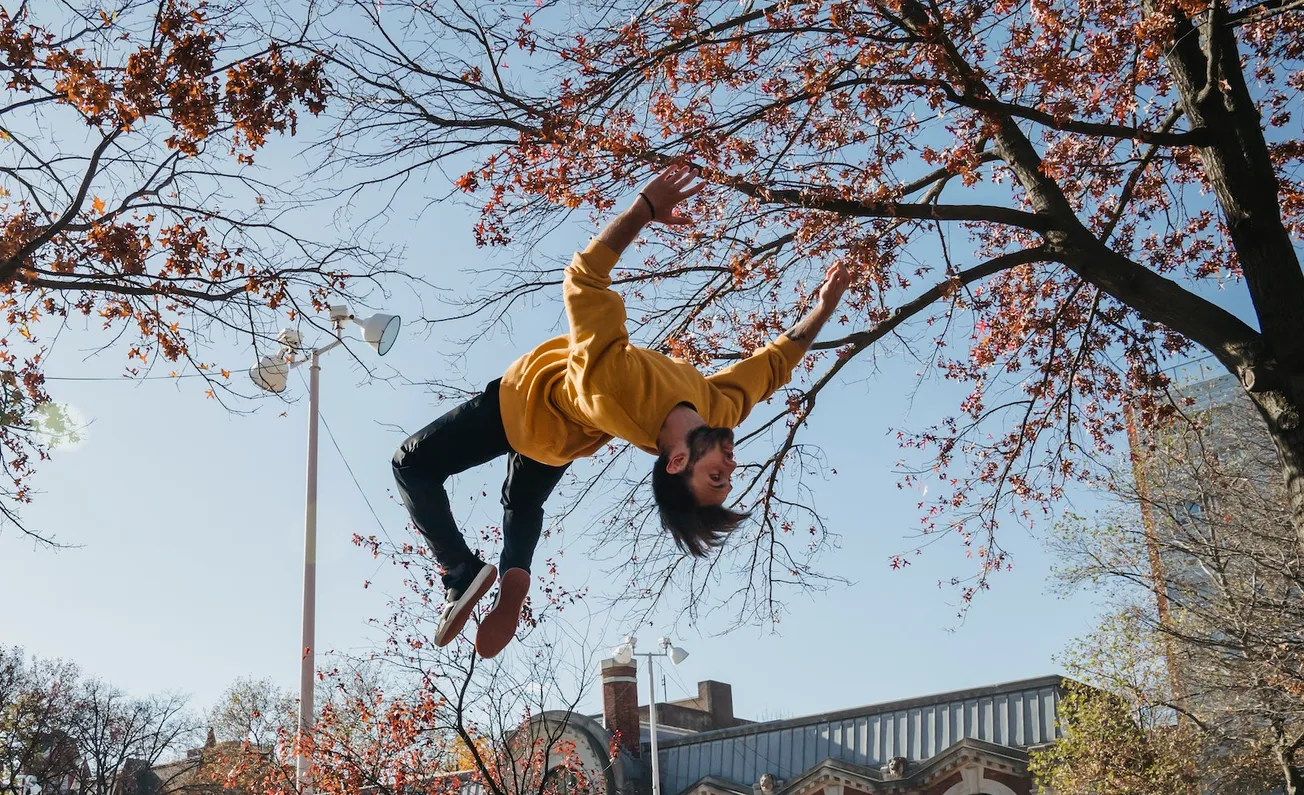 Guy doing backflip in city park