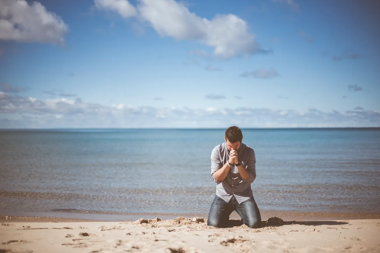 man kneeling down near shore