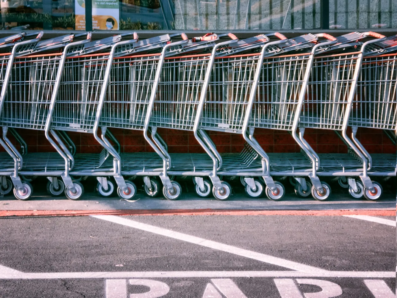 red and silver shopping cart on gray asphalt road during daytime