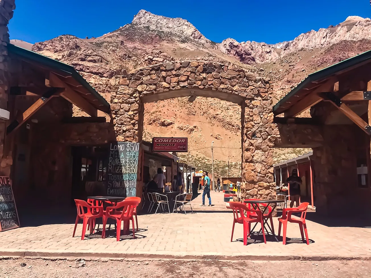 red plastic chairs and tables near brown concrete building during daytime