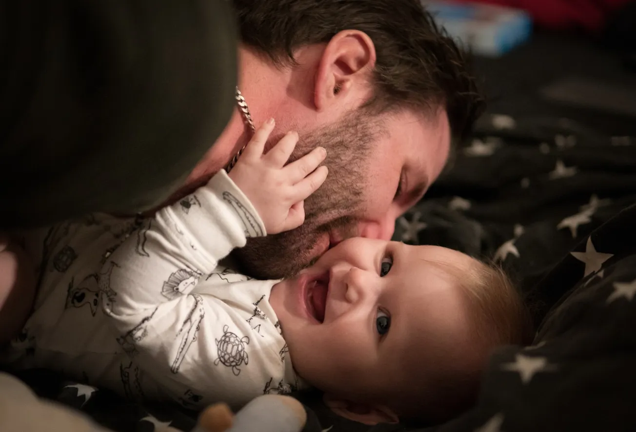 man kissing baby