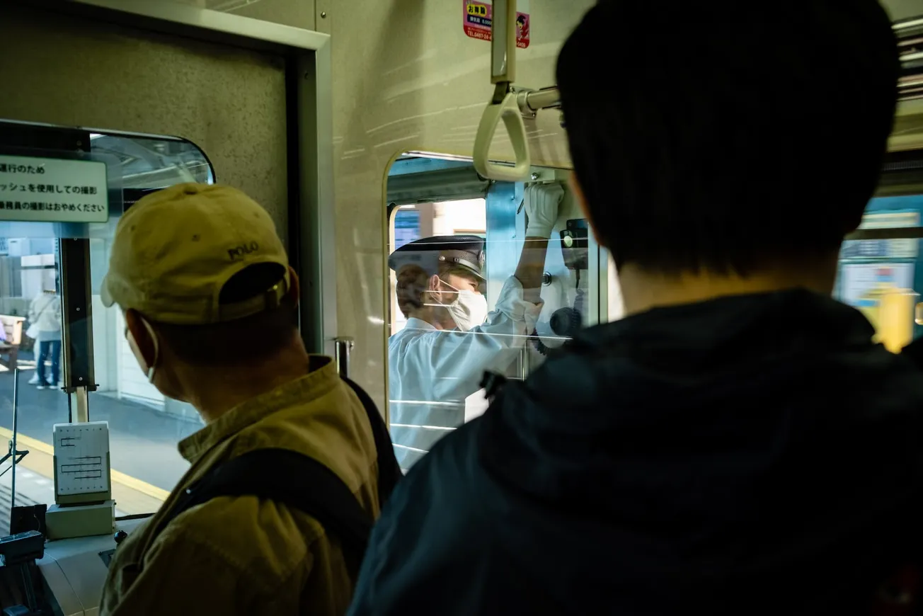 a man in a yellow hat is looking out the window of a bus