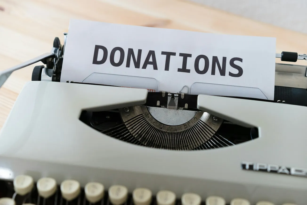 a close up of a typewriter with a donation sign on it