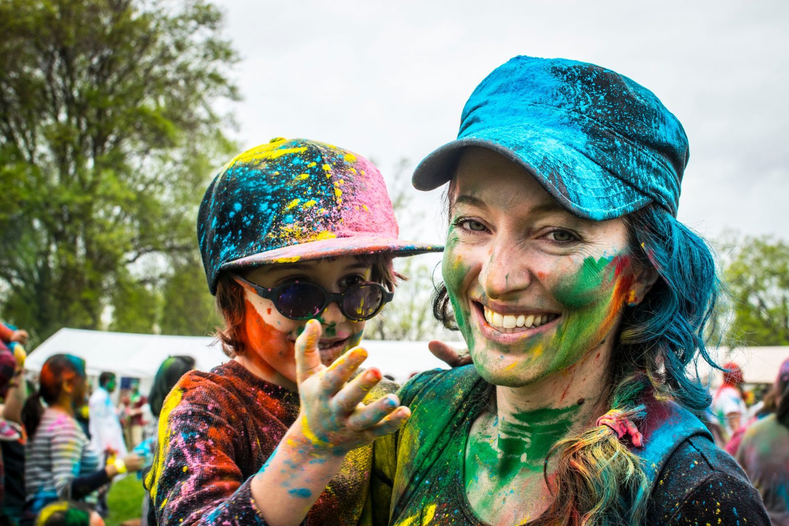 woman carrying child on color run