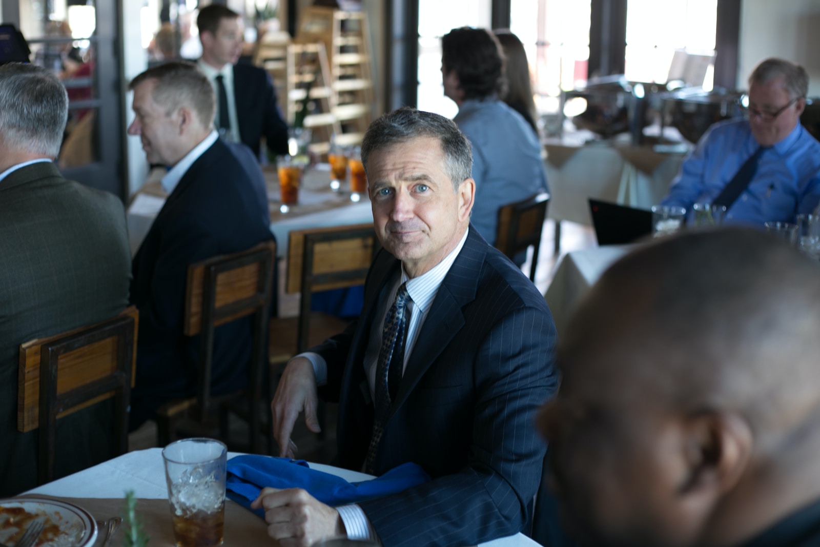 man in black suit jacket sitting on chair